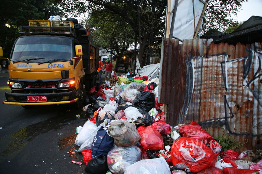 Petugas mengangkut tumpukan sampah di Jalan HOS Cokroaminoto, Larangan, Kota Tangerang, Banten, Selasa (25/4/2023). Kurangnya kesadaran masyarakat untuk memilah sampah di rumah membuat jumlah sampah yang dibuang meningkat.