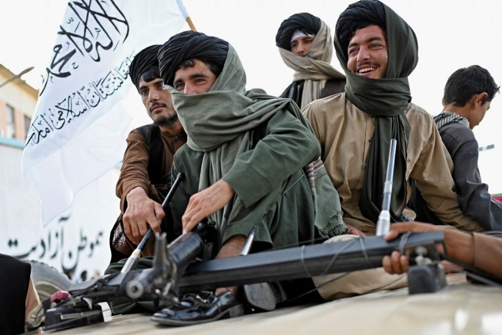 Para anggota Taliban berkonvoi saat mereka merayakan satu tahun penarikan pasukan pimpinan AS dari Afghanistan, dekat bandara di Kabul pada 31 Agustus 2022. 
