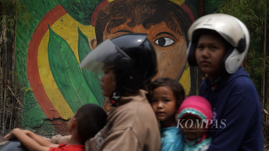 Warga tanpa mengenakan masket melintasi mural di Sukapura, Cilincing, Jakarta Utara, Kamis (31/8/2023). Polusi udara turut memicu lonjakan kasus infeksi saluran pernapasan atas (ISPA) di Jabodetabek.