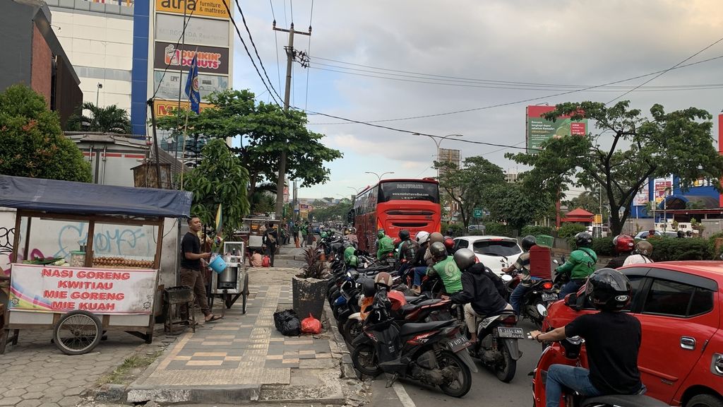 Penggunaan bahu jalan sebagai parkir secara liar di Jalan Margonda Raya, Depok, Kamis (9/3/2023). Pemkot Depok berencana memberlakukan “on street parking” di ruas jalan sepanjang 5,1 kilometer ini.