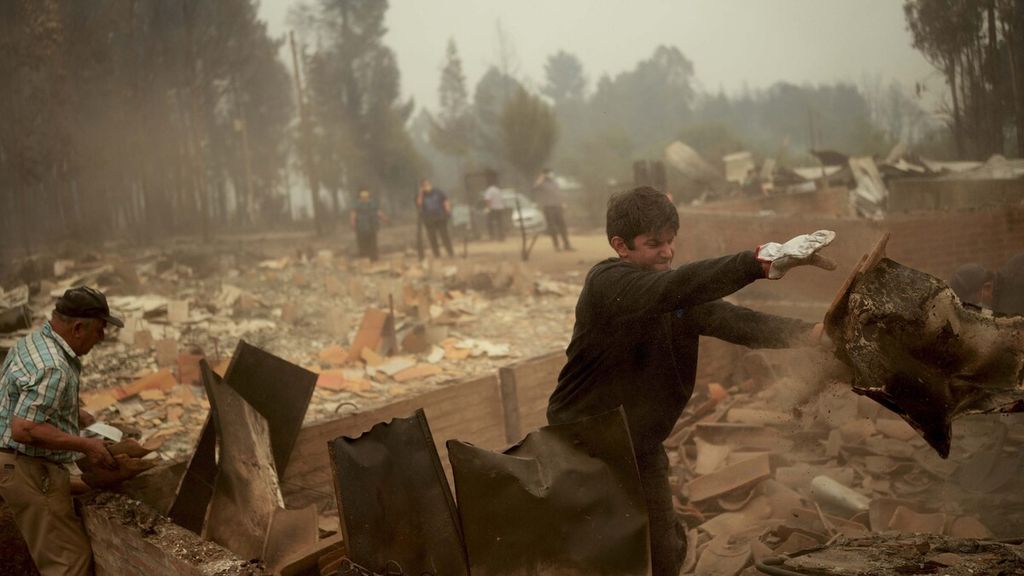 Warga membersihkan puing-puing setelah kebakaran hutan melanda daerah di Santa Juana, Chile, Sabtu (4/2/2023). 