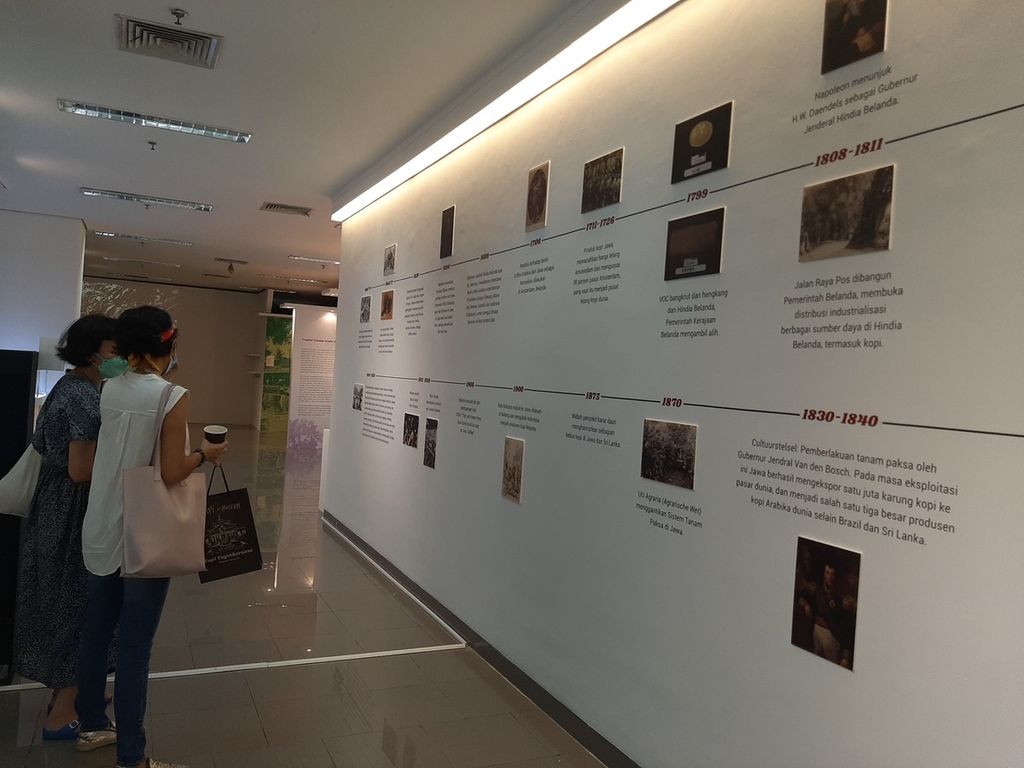 Pengunjung menyaksikan perjalanan kopi di Indonesia dalam pameran Kopi Togetherness di Area Sunken, Museum Nasional,  Jakarta, Jumat (18/11/2022).