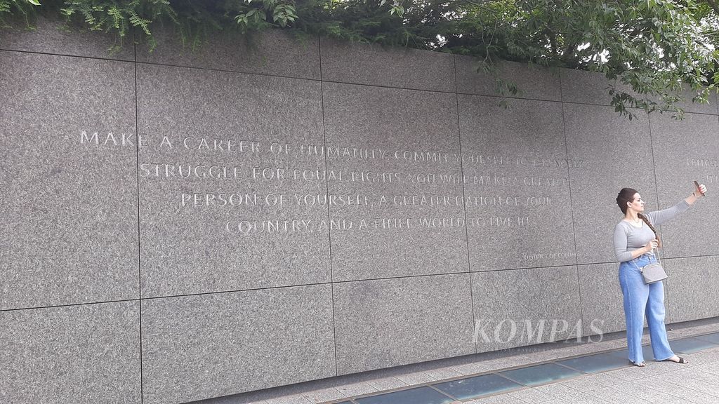 Seorang pengunjung berswafoto di kutipan yang berada di Martin Luther King Jr Memorial di Washington DC, Amerika Serikat, 18 Juli 2022.