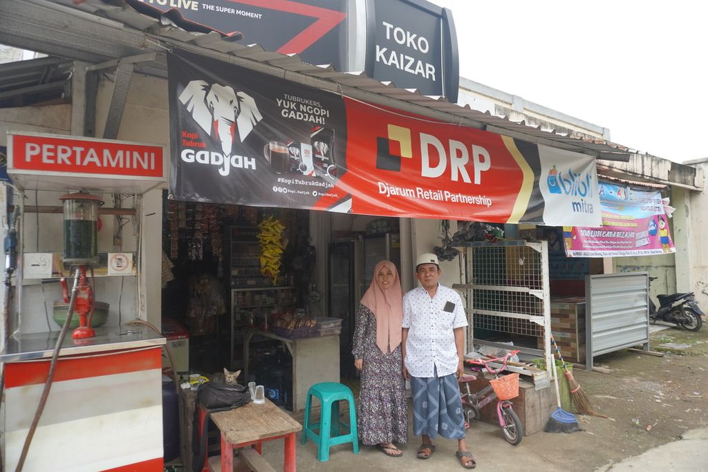 Fadlali (44) dan istrinya, Masodaturrahmaniyah (36), perantau asal Sumenep, berdiri di depan salah satu dari empat toko kelontong mereka di kawasan Cijingga, Cikarang Selatan, Kabupaten Bekasi, Jawa Barat, Kamis (10/11/2022). 
