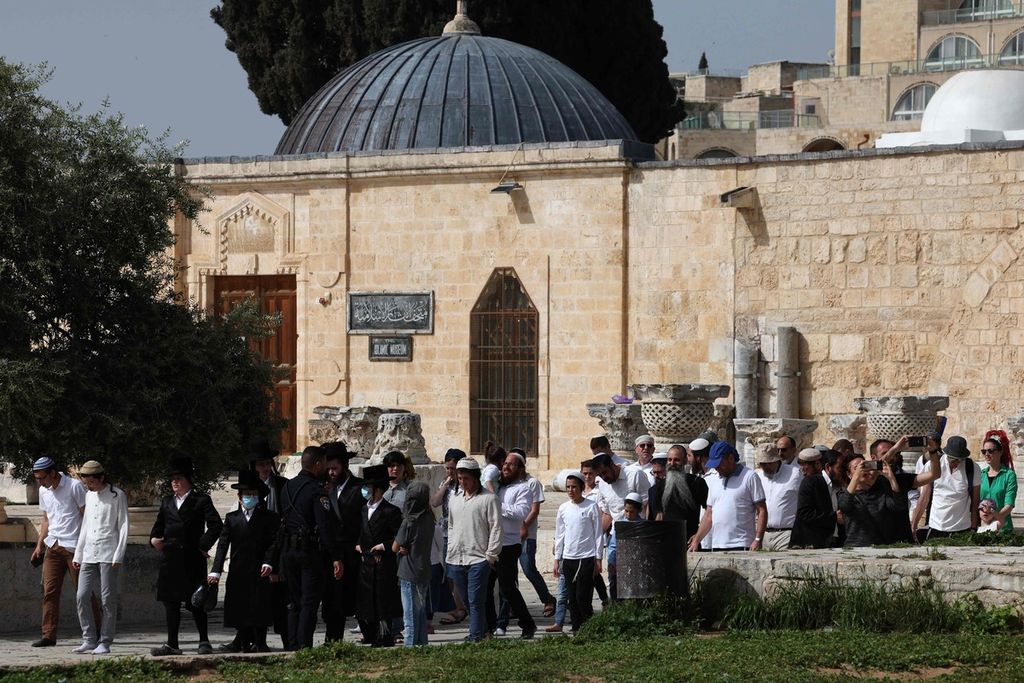 Para pengunjung Yahudi di bawah proteksi aparat keamanan Israel berjalan di kompleks Masjidil Aqsa atau Bukit Kuil (sebutan bagi umat Yahudi) di Jerusalem, Minggu (9/4/2023), pada hari libur Paskah Yahudi yang bersamaan dengan bulan suci Ramadhan. 