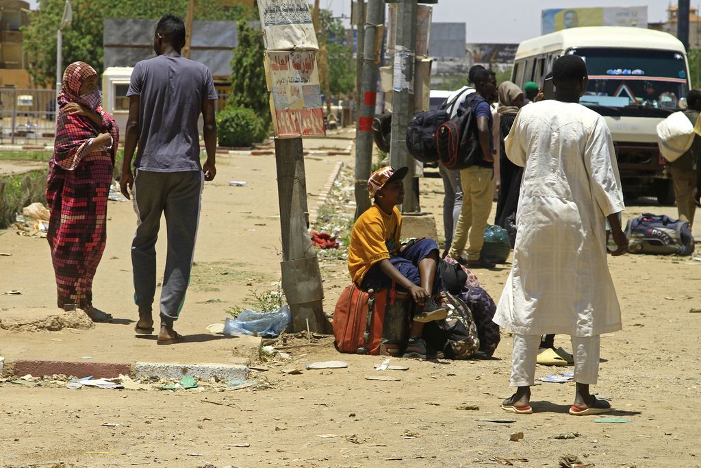 Warga menunggu bus untuk mengungsi di selatan Khartum, ibu kota Sudan, 18 April 2023, menyusul pertempuran sengit antara militer dan kelompok milisi yang bertikai. 