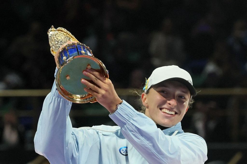 Petenis Polandia, Iga Swiatek, mengangkat trofi sebagai juara WTA 1000 Doha 2023 di Khalifa International Tennis Squash Complex, Doha, 18 Februari 2023. Swiatek menjuarai turnamen WTA 1000 Doha tahun 2022, 2023, dan 2024 beruntun.