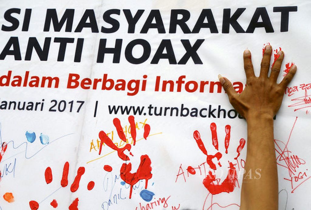 Warga membubuhkan cap tangan saat sosialisasi dan deklarasi Masyarakat Indonesia Anti Hoax di Hari Bebas Kendaraan Bermotor di Jakarta, Minggu (8/1/2017). Deklarasi yang juga dilakukan di lima kota lainnya di Indonesia itu bertujuan untuk membersihkan media sosial dari berita bohong alias Hoax.