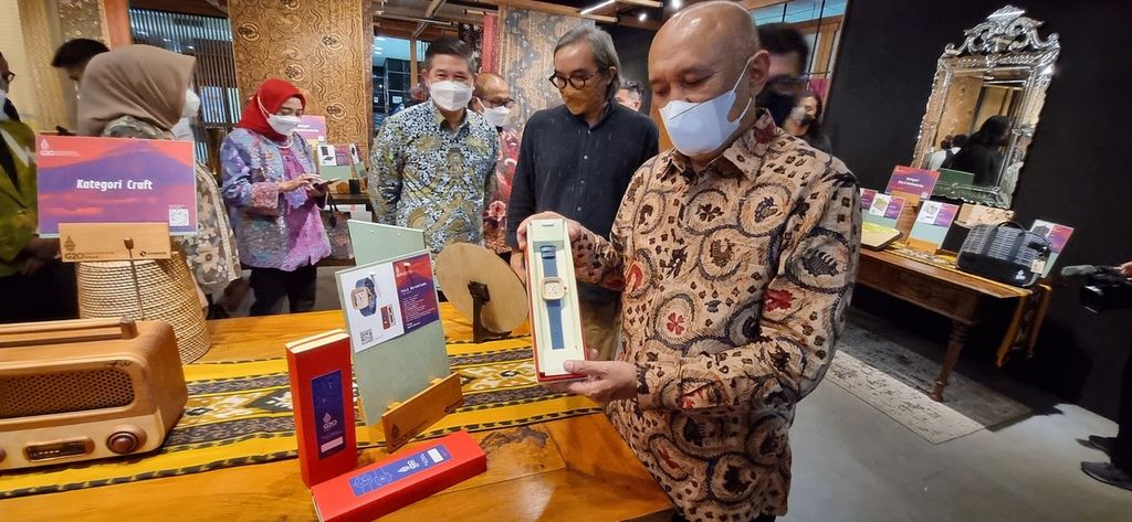 Sebanyak 20 produk UKM berhasil terkurasi menjadi produk resmi Presidensi G20 oleh Kementerian Koperasi dan UKM. Menteri Koperasi dan UKM Teten Masduki (kanan) memperlihatkan produk UKM yang lolos kurasi di Smesco Indonesia di Jakarta, Selasa (26/7/2022). 
