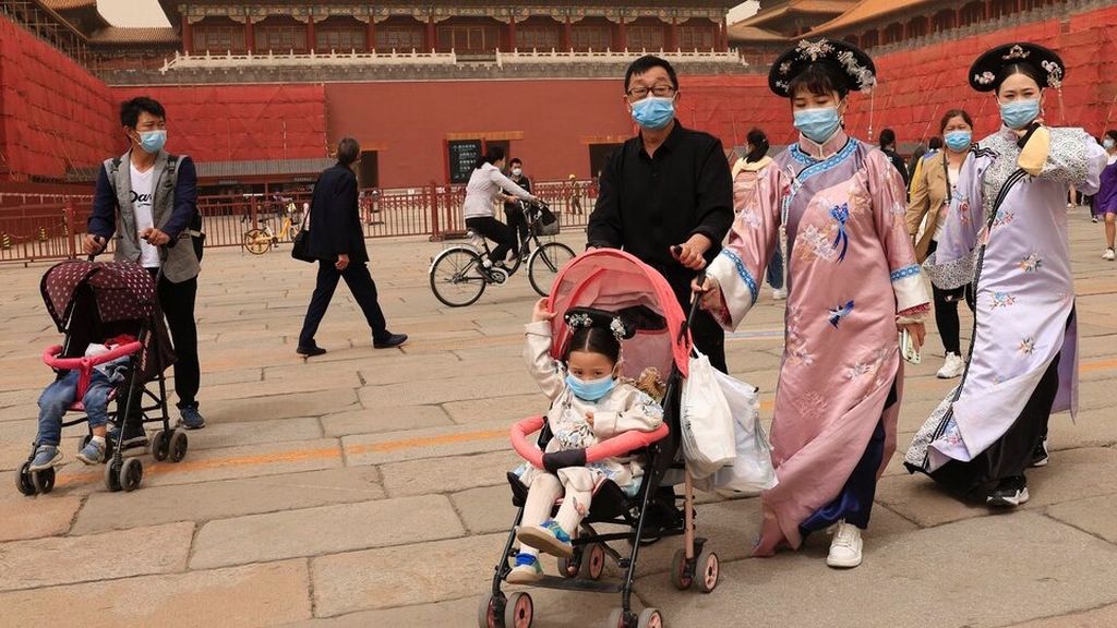 Penduduk yang mengenakan kostum tradisional mengunjungi Kota Terlarang di Beijing, China. Pertumbuhan populasi China turun mendekati nol karena lebih sedikit pasangan yang memiliki anak. AP/NG HAN GUAN