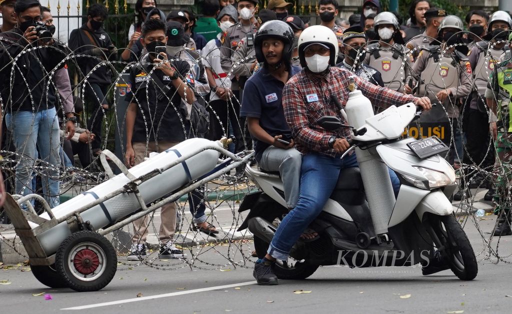 Petugas pengantar oksigen terhalang kawat berduri polisi yang dipasang untuk menahan aksi mahasiswa dari beberapa perguruan tinggi di Kota Bogor ketika menggelar aksi di Jalan Juanda, Kota Bogor, menolak tiga periode kepemimpinan Presiden Joko Widodo, Jumat (8/4/2022). 