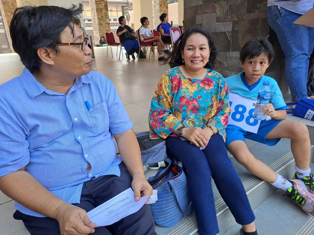 Kenzi Hamonangan Batubara (kanan) ditemui kedua orangtuanya, Feri Aryanto (kiri) dan Desi (tengah), saat ujian masuk SMP Kanisius, Jakarta, Rabu (18/10/2023).