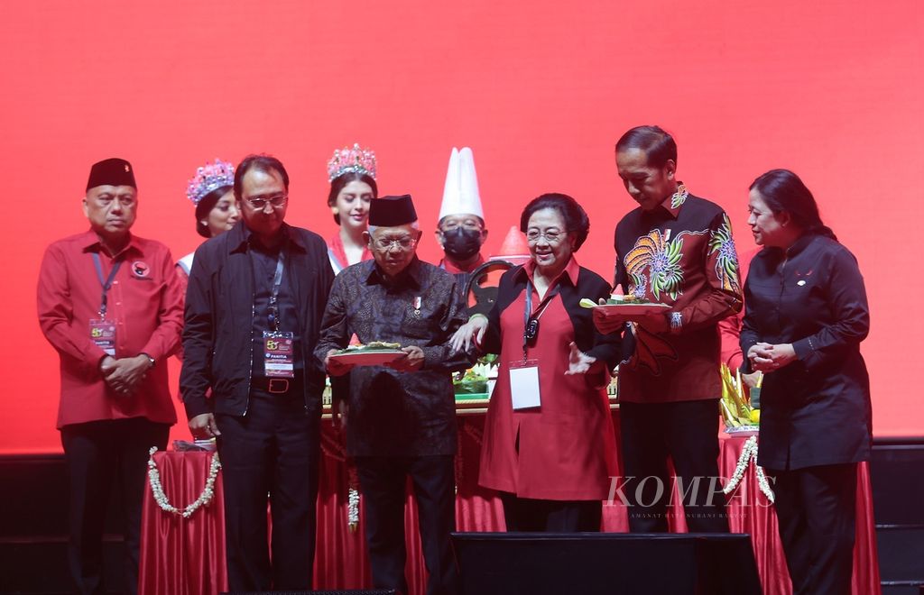 Presiden Joko Widodo (depan dua dari kanan) didampingi Wakil Presiden Ma'ruf Amin (depan dua dari kiri) menerima nasi tumpeng dari Ketua Umum PDI Perjuangan Megawati Soekarnoputri (tengah) dalam puncak acara HUT PDI Perjuangan ke-50 di Jakarta, Selasa (10/1/2023). 