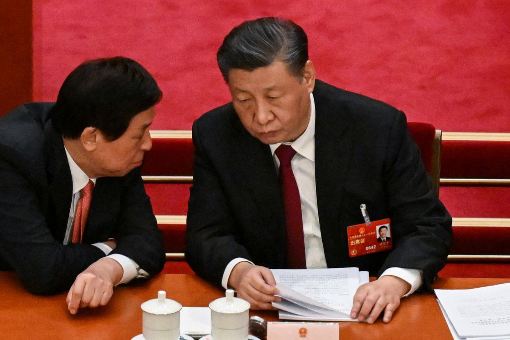 Presiden China Xi JInping berbicara dengan Ketua Kongres Rakyat Nasional (NPC) Li Zhanshu pada sesi pembukaan sidang tahunan NPC di gedung Balai Agung Rakyat, Beijing, China, Minggu (5/3/2023). 
