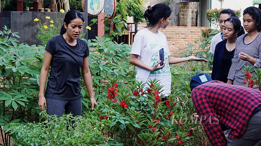 Salah satu pendiri Kebun Kumara, Soraya Cassandra (kiri), menunjukkan jenis-jenis tanaman kepada beberapa anak muda, Sabtu (2/12), di Situ Gintung, Tangerang Selatan, Banten.