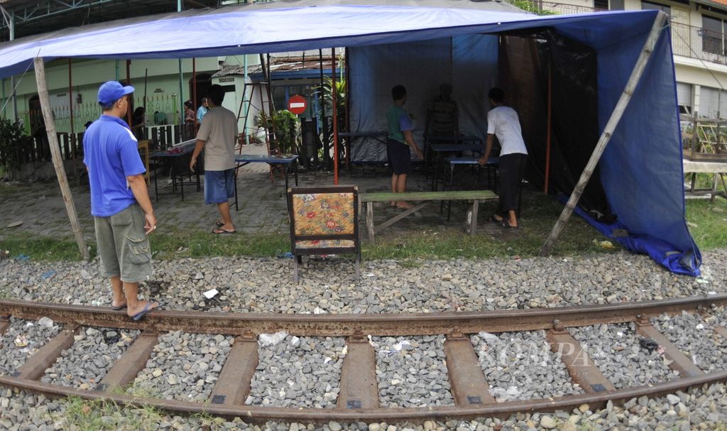 Warga Kampung Gundih, Surabaya, mempersiapkan pembuatan tempat pemungutan suara (TPS) di tepi rel kereta api karena kurangnya lahan untuk membuat TPS, Rabu (8/4/2009). 