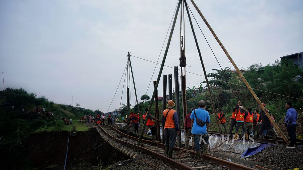 Kesibukan pekerja lapangan PT KAI memulai memasang tiang pancang penahan tanah di ruas rel kereta api jurusan Bogor-Sukabumi yang terdampak longsor di Kampung Sirnasari, Empang, Kota Bogor, Jawa Barat, Rabu (15/3/2023). 