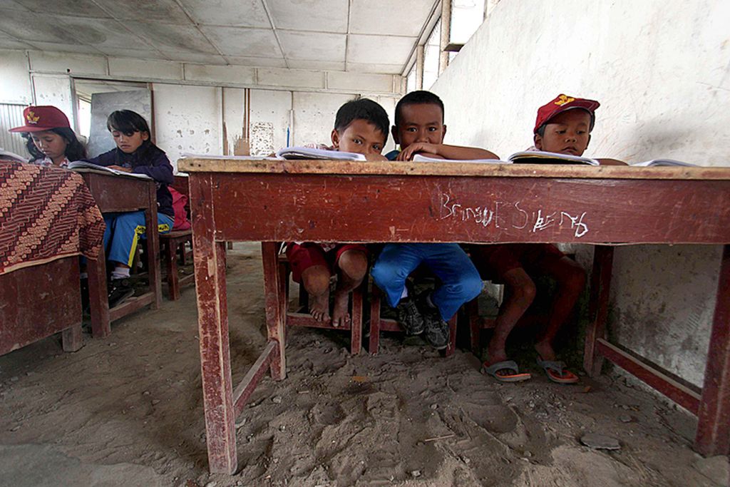 Sejumlah murid sekolah dasar belajar tanpa alas kaki di ruang kelas SDN 046417 berlantai tanah di Desa Naman, Naman Teran, Karo, Sumatera Utara (18/1/2017). Walaupun kondisi sekolah terkesan sederhana, proses belajar di sekolah itu tetap berlangsung. 