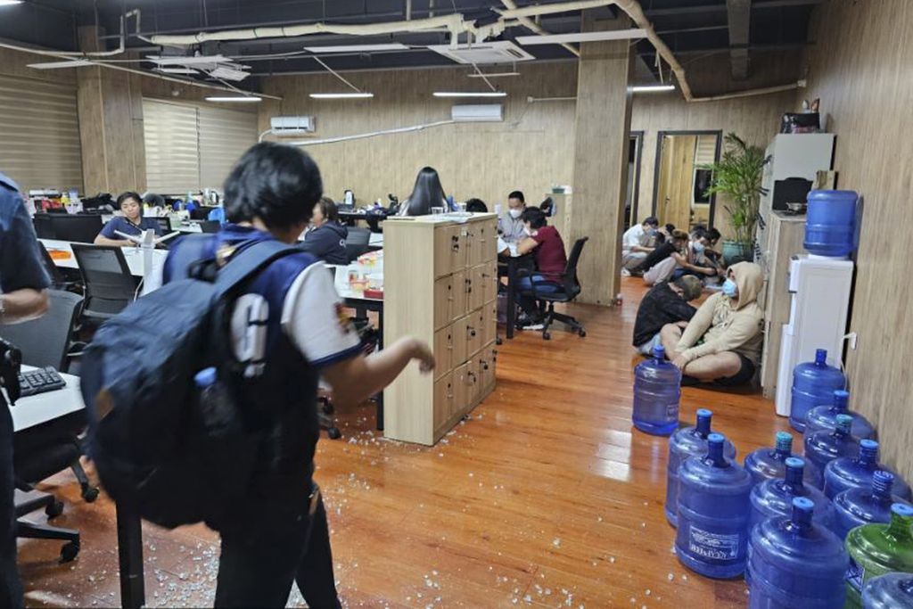 Dalam foto yang disediakan oleh Kelompok Anti-Kejahatan Siber Kepolisian Nasional Filipina, polisi berjalan masuk ke salah satu kantor yang mereka razia di Las Pinas, Filipina, 27 Juni 2023.