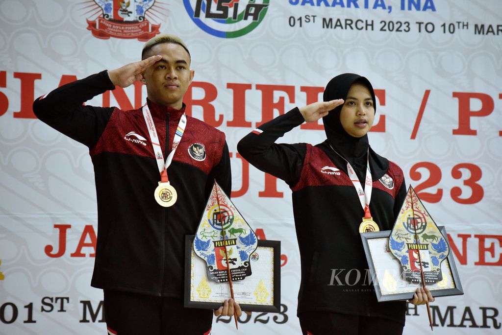 Pasangan Indonesia Audrey Zahra Dhiyaanisa/Afif Izzuddin hormat kepada bendera Merah-Putih usai menerima medali emas nomor pertandingan tim campuran senapan angin 10 meter Piala Asia Senapan dan Pistol 2023 di Lapangan Tembak Senayan, Jakarta, Minggu (5/3/2023). 