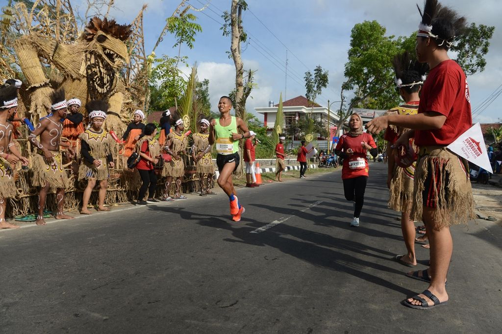 Sejumlah siswa dari Papua menghibur pelari Borobudur Marathon 2019 powered by Bank Jateng yang melintas di Desa Wringinputih, Kecamatan Borobudur, Magelang, Jawa Tengah, Minggu (17/11/2019). 