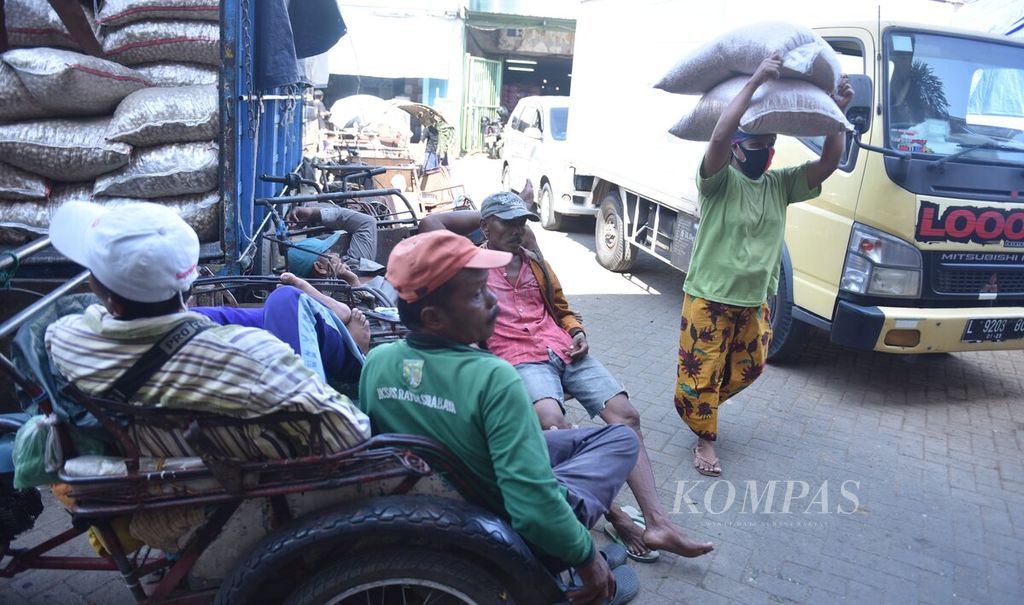 Buruh perempuan membawa beban di atas kepala di Pasar Pabean, Kota Surabaya, Jawa Timur, Senin (23/5/2022). Buruh perempuan tersebut dapat membawa beban hingga 50 kilogram di kepala mereka. 