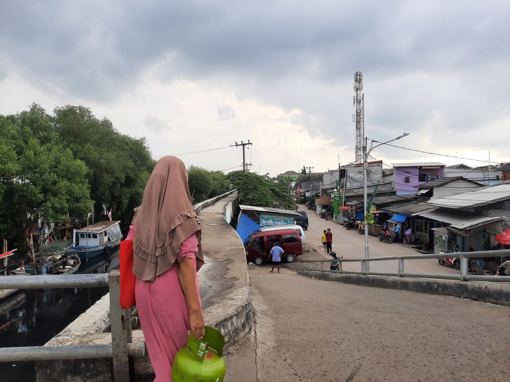 Warga melintasi jembatan di Kelurahan Kamal Muara, Kecamatan Penjaringan, Jakarta Utara, Kamis (30/3/2023).
