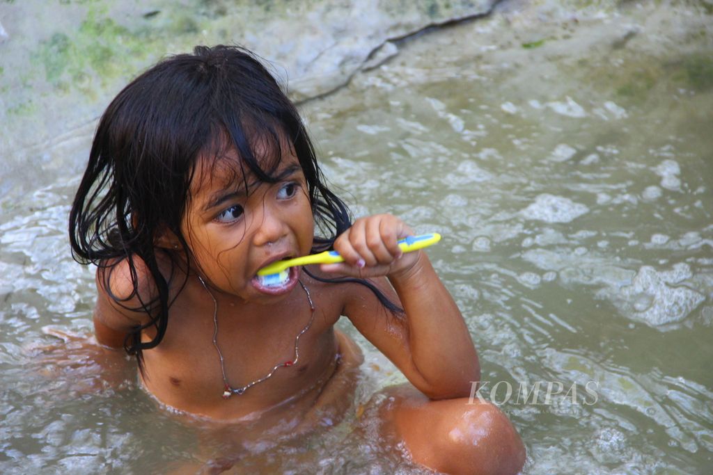 Seorang bocah menyikat gigi menggunakan air keruh. Sejumlah warga di Desa Manulea, Kecamatan Sasitamean, Kabupaten Malaka, Nusa Tenggara Timur, menggunakan air keruh di Kali Babeko untuk mandi dan cuci, seperti pada Rabu (21/10/2020). Daerah itu mengalami krisis air bersih sejak lama.