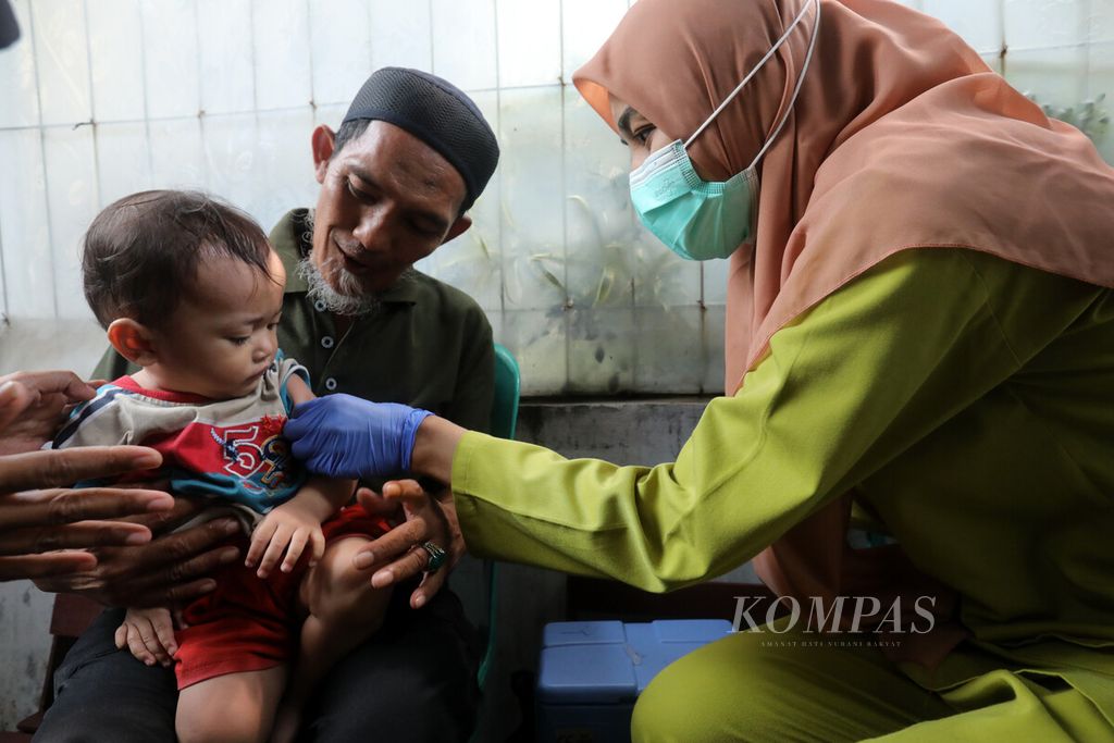 Tenaga kesehatan dari Puskesmas Kelurahan Cililitan memberikan suntikan imunisasi kepada anak balita di permukiman di kawasan RW 001 Kelurahan Cililitan, Kecamatan Kramatjati, Jakarta Timur, Senin (22/8/2022).