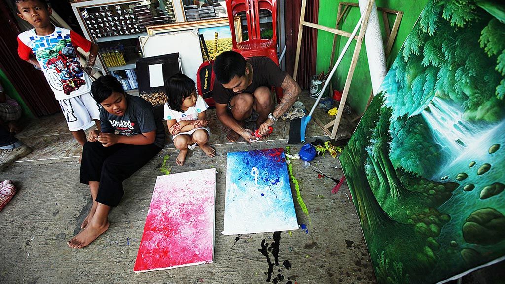 Sejumlah anak melihat proses berkarya Didin, salah satu pelukis yang mewarisi kakeknya yang merupakan perintis kegiatan melukis di Jelekong, Kabupaten Bandung, Jawa Barat.