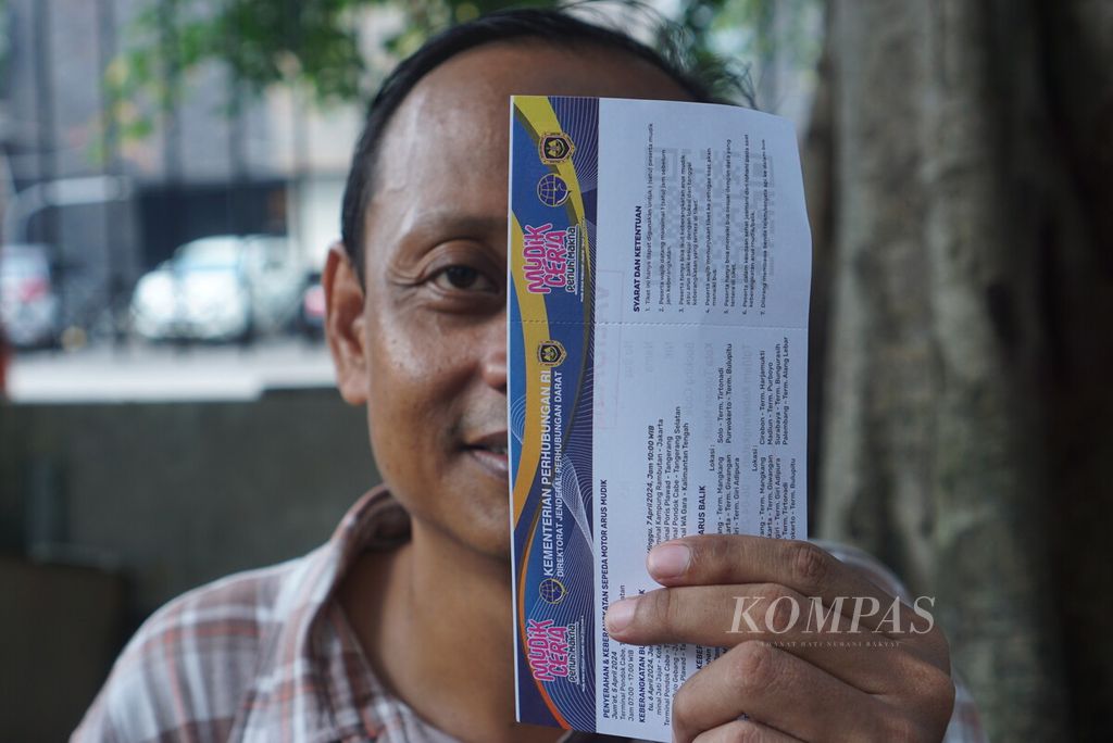 Joko Mursito (41) berpose dengan dua tiket mudik gratis Kementerian Perhubungan sesaat setelah verifikasi data di Gelanggang Olahraga Bulungan, Jakarta, Sabtu (30/3/2024).