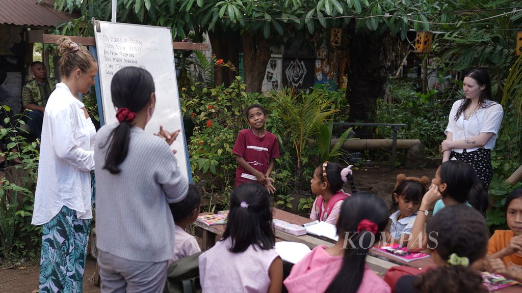 Kristen (kiri) dan Tiah (kanan), relawan warga negara Australia, mengajar anak-anak belajar memperkenalkan diri menggunakan bahasa Inggris di Taman Daun Lembata, Nusa Tenggara Timur, Kamis (10/8/2023). 