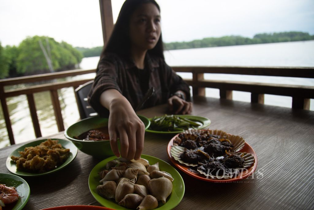 Warga menyantap siput gonggong rebus di rumah makan boga bahari (<i>seafood</i>) Gerai Nelayan 2M di Kampung Tua Mentarau, Kecamatan Sekupang, Batam, Kepulauan Riau, Sabtu (29/4/2023). 