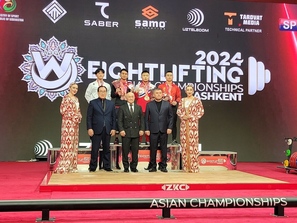 Lifter Indonesia, Ricko Saputra (dua dari kiri), berpose di podium setelah meraih dua perak dan satu perunggu di kelas 61 kg putra Kejuaraan Angkat Besi Asia di Tashkent, Uzbekistan, Minggu (4/2/2024).