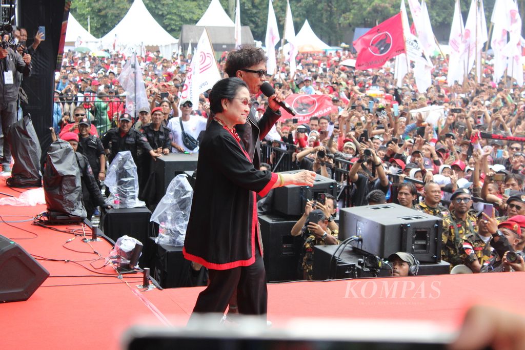 Ketua Umum Partai Demokrasi Indonesia Perjuangan Megawati Soekarnoputri bersama vokalis band Slank, Kaka, berjoget di hadapan ribuan pendukung Ganjar Pranowo-Mahfud MD saat kampanye terbuka di Lapangan Tegalega, Kota Bandung, Jawa Barat, Minggu (21/1/2024).
