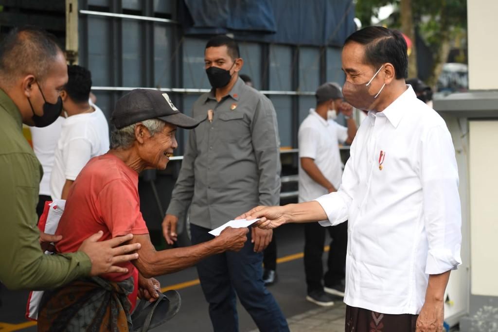 Presiden Joko Widodo membagikan bantuan di Istana Kepresidenan Tampaksiring, Kabupaten Gianyar, Kamis (5/5/2022). 