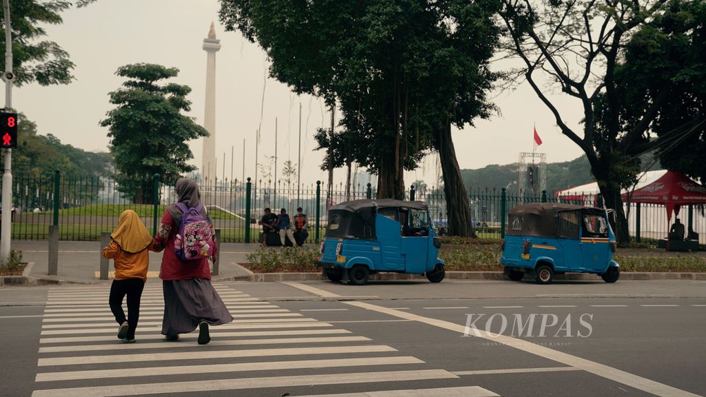 Warga menyeberang Jalan Medan Merdeka Selatan, Senin (19/9/2022). 