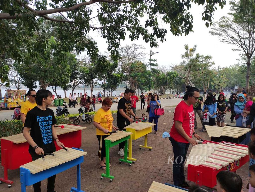 Sejumlah pemain kolintang yang tergabung dalam Sanggar Bapontar menghibur para pengunjung Waduk Pluit, Jakarta, Minggu (10/9/2023).