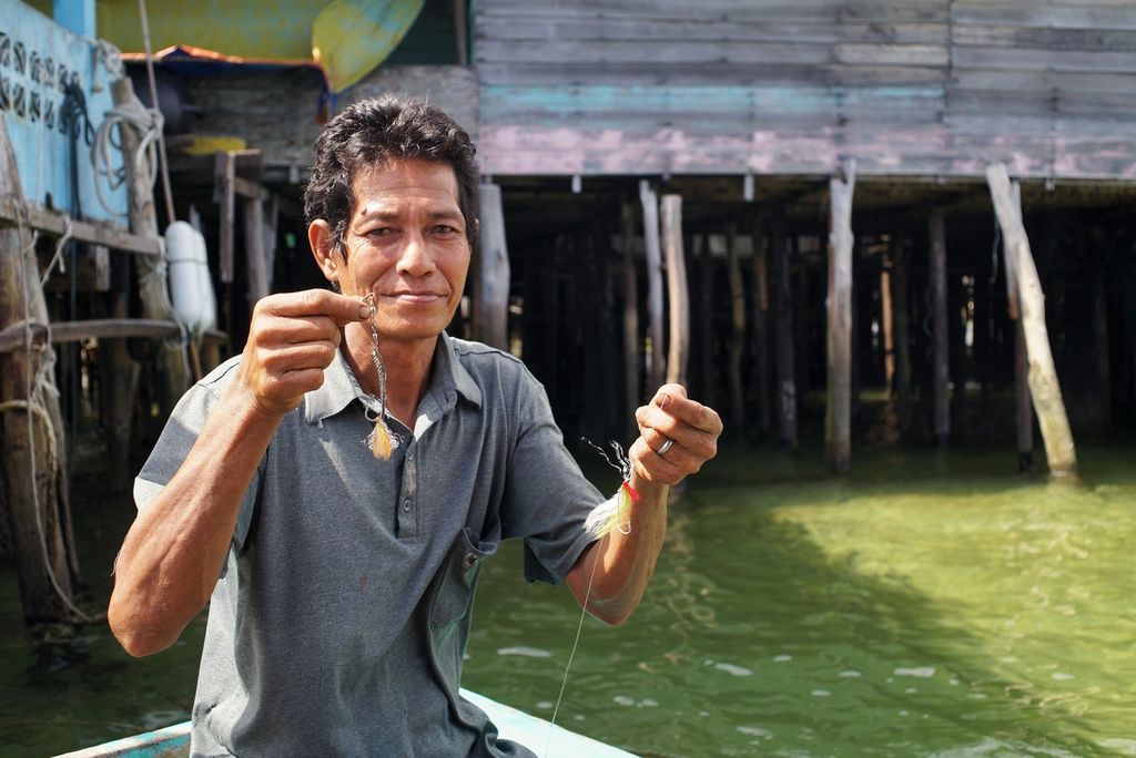 Bujang (65), nelayan di Teluk Baruk, Kecamatan Bunguran Timur, Natuna, Kepulauan Riau, menunjukkan alat pancing yang digunakan untuk menangkap ikan secara tradisional, Kamis (9/1/2020). 