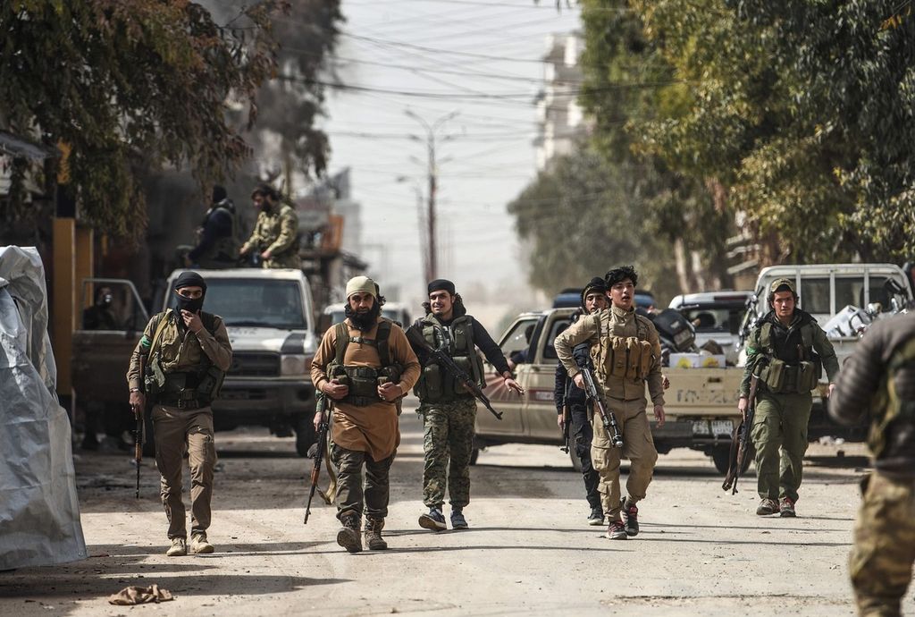 Anggota milisi Arab Suriah dukungan Turki menyusuri jalan-jalan di kota Afrin setelah merebut wilayah barat laut kota di Suriah utara itu dari milisi Unit Perlindungan Rakyat (YPG) Kurdi, Minggu (18/3/2018).