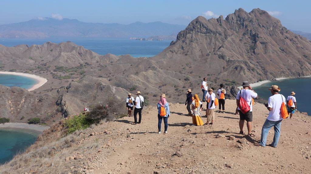 Sejumlah wisatawan menyaksikan keindahan Pantai Pulau Padar, Labuan Bajo, Manggarai Barat, Nusa Tenggara Timur, dari salah satu puncak bukit Pulau Padar, Kamis (14/11/2019) pagi. Pulau Padar merupakan bagian dari destinasi wisata Taman Nasional Komodo.