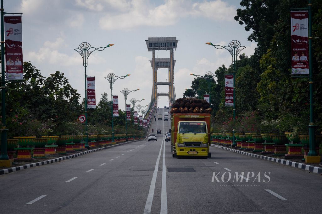 Truk pengangkut sawit melintas di Jembatan Tengku Agung Sultanah Latifah yang menjadi ikon Kabupaten Siak sekaligus ikon Provinsi Riau, Senin (7/8/2023). 