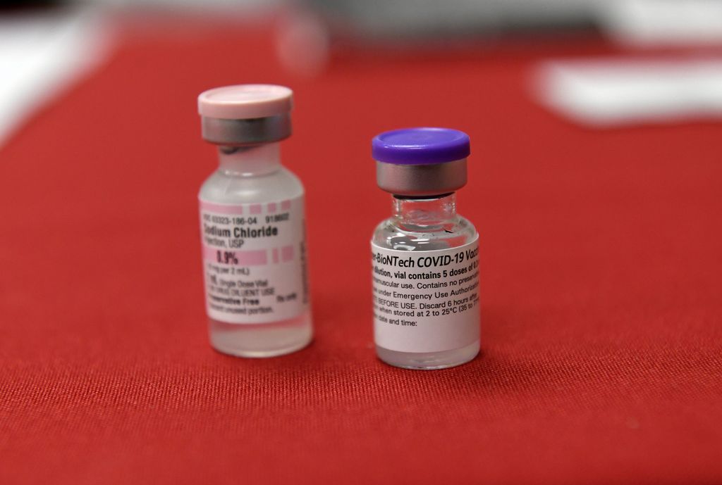 Vaksin Covid-19 (kanan) berada di sebelah botol natrium klorida sebelum dilarutkan dan siap untuk diberikan kepada petugas kesehatan lini depan yang menunggu di Rumah Sakit UCHealth Poudre Valley di Fort Collins, Colorado, Amerika Serikat, 14 Desember 2020. 