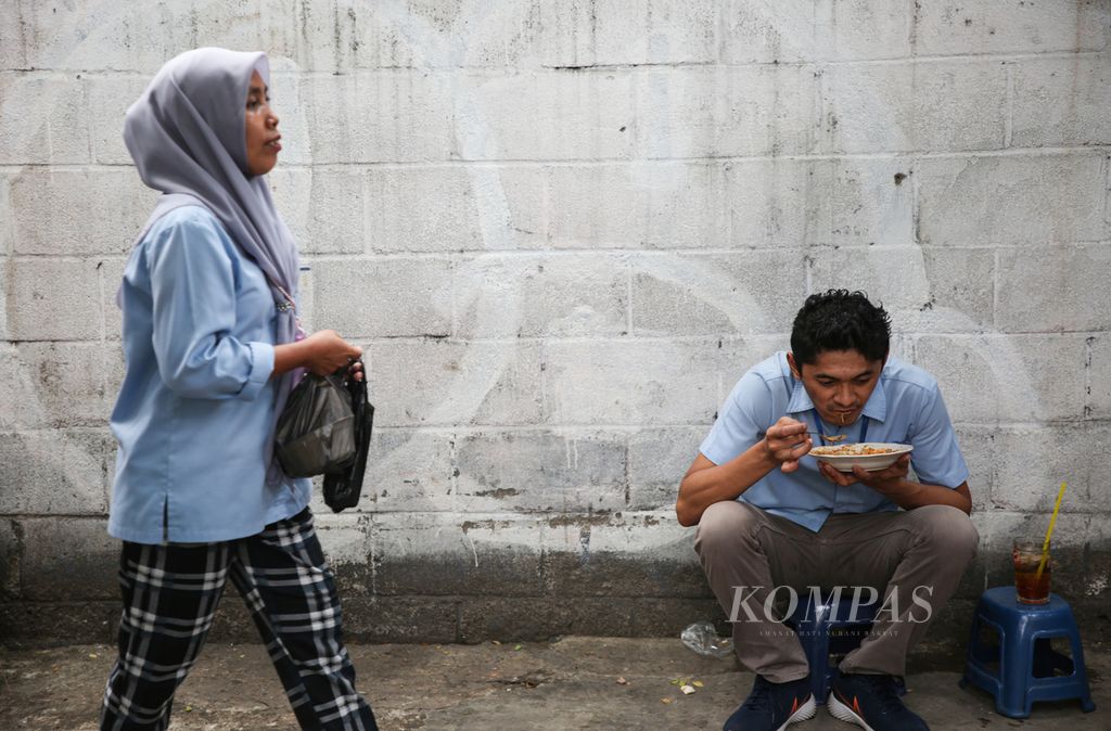 Buruh menikmati makan siang dari pedagang yang mangkal di luar area pabrik di kawasan Karawaci, Kota Tangerang, Banten, Rabu (22/11/2023). Upah minimum provinsi (UMP) 2024 Banten sebesar Rp 2.727.812, naik Rp 66.532 atau 2,50 persen dibanding tahun 2023. 