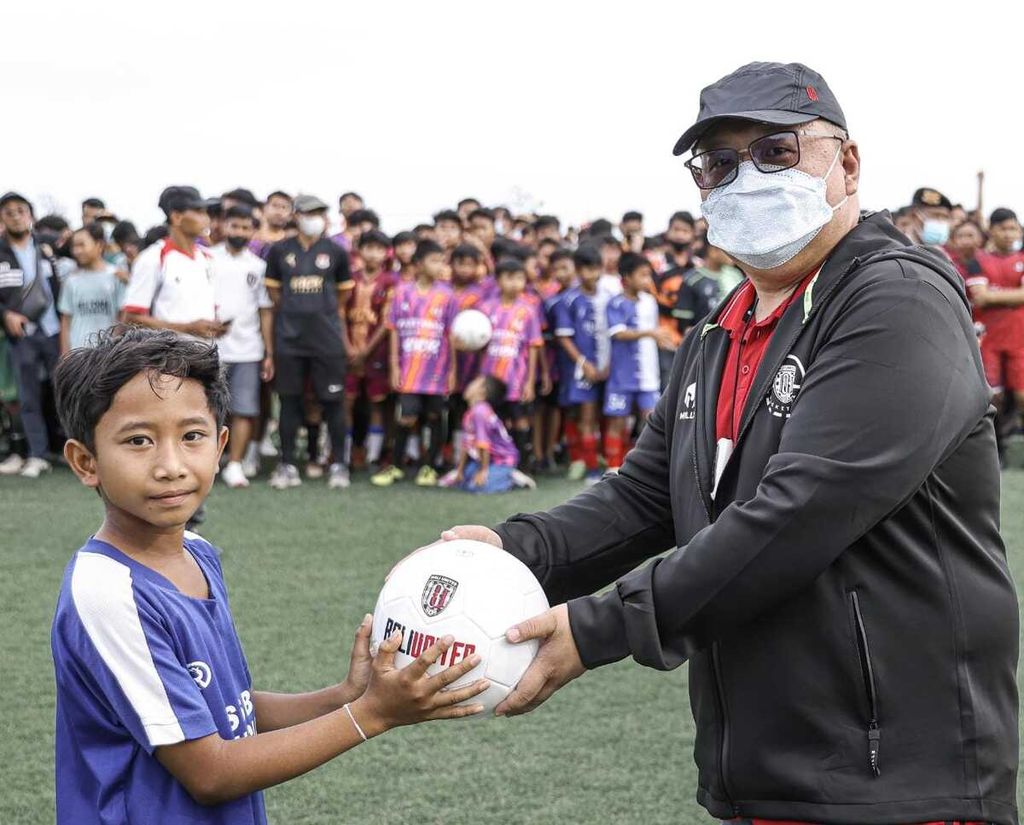 Yabes Tanuri gave the ball to a boy as a symbol of the Bali United Coaching Clinic held in Gianyar, Bali, January 2022. Bali United held the event to look for young players from the Island of the Gods.