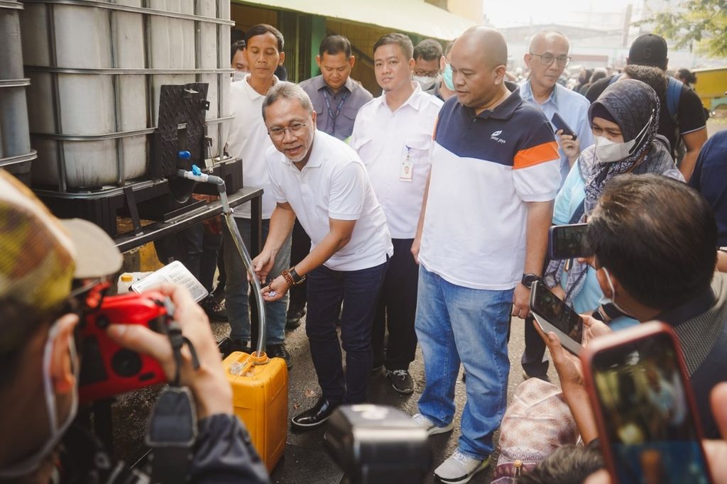 Menteri Perdagangan Zulkifli Hasan mengalirkan minyak goreng curah dari toren atau tandon penampung ke jeriken saat berkunjung ke Pasar Kramat Jati, Jakarta Timur, Sabtu (25/6/2022).