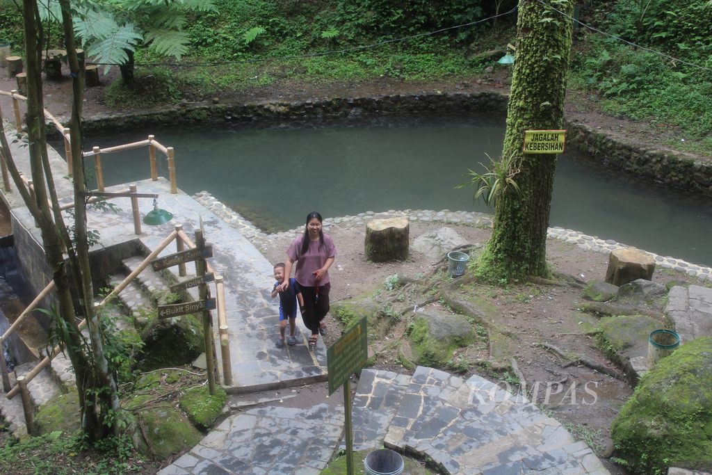 Pengunjung berjalan di area Curug Cipeuteuy di Desa Bantaragung, Kacamatan Sindangwangi, Kabupaten Majalengka, Jawa Barat, Senin (22/4/2024). Di area itu, pengunjung dapat menikmati air terjun atau curug, berendam di kolam, hingga berkemah di tengah pepohonan pinus. Masyarakat mengembangkan destinasi wisata ini sejak 2009.