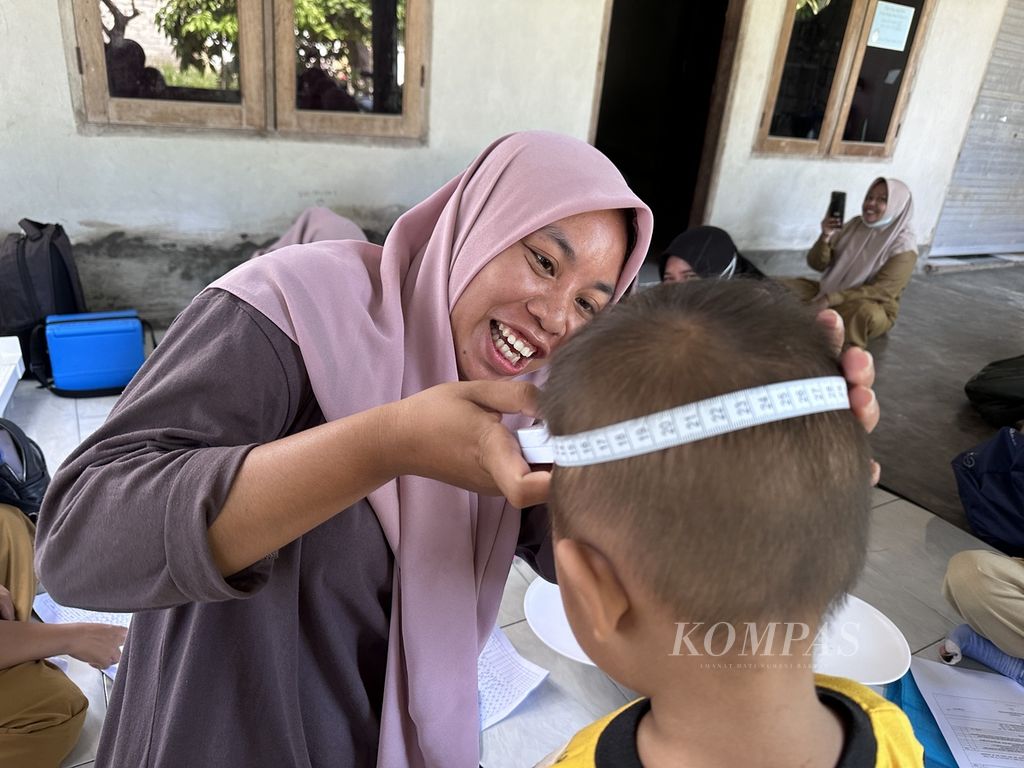 Bongor Mekarasi Hamlet Posyandu cadres measure the head circumference of toddlers during Family Posyandu activities in Bongor Hamlet, Taman Ayu Village, West Lombok, West Nusa Tenggara, Tuesday (12/12/2023). Family Posyandu, which currently numbers more than 7,700 units, is an important part of preventing and reducing stunting rates in West Nusa Tenggara.