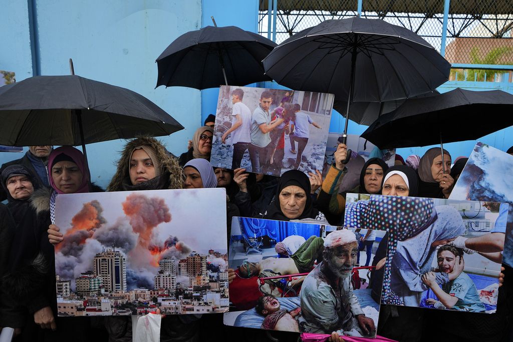 Para pendukung Palestina mengangkat poster-poster bergambar pengeboman masif Israel di jalur Gaza dalam unjuk rasa menyuarakan dukungan pada Badan Bantuan Sosial dan Pekerja Perserikatan Bangsa-Bangsa (UNRWA) di depan kantor pusat UNRWA di Beirut, Lebanon, Selasa (30/1/2024). 