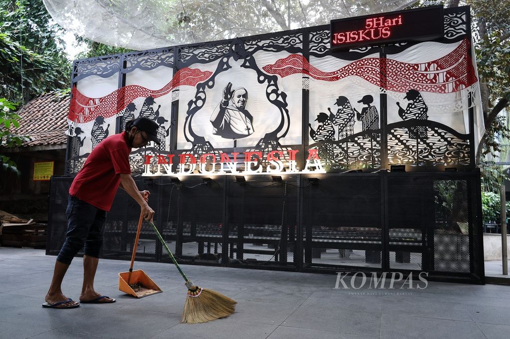 Petugas menyapu di depan dekorasi bergambar Paus Fransiskus di Gereja Katedral Jakarta, Kamis (29/8/2024). Katedral Jakarta menyiapkan berbagai dekorasi khusus untuk menyambut kunjungan Paus Fransiskus ke Indonesia pada 3-6 September 2024. 